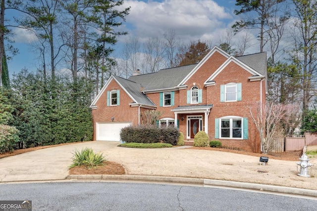 view of front of property featuring a garage, driveway, brick siding, and a chimney