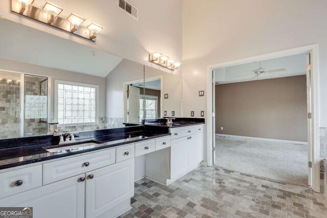 bathroom featuring lofted ceiling, a sink, visible vents, a ceiling fan, and double vanity