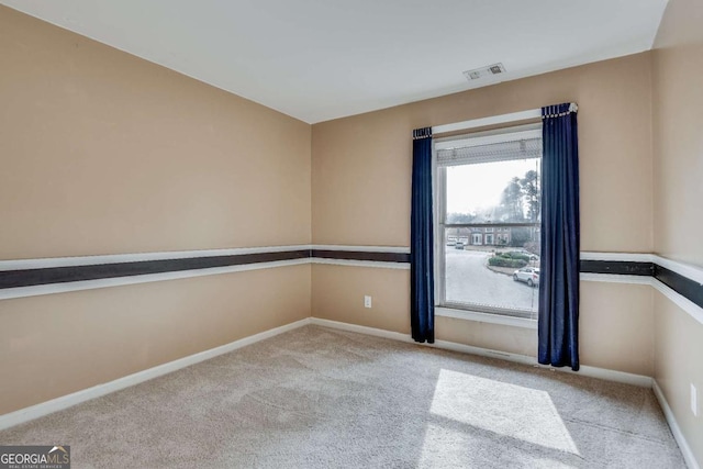 carpeted empty room with visible vents and baseboards