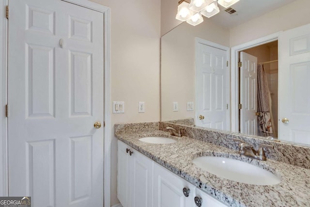 full bath featuring double vanity, a sink, and visible vents