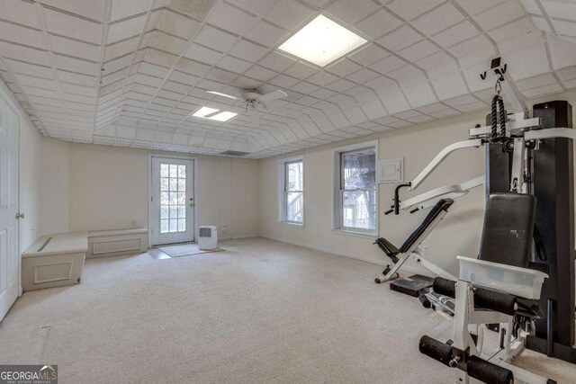 exercise area with a ceiling fan, baseboards, and carpet flooring