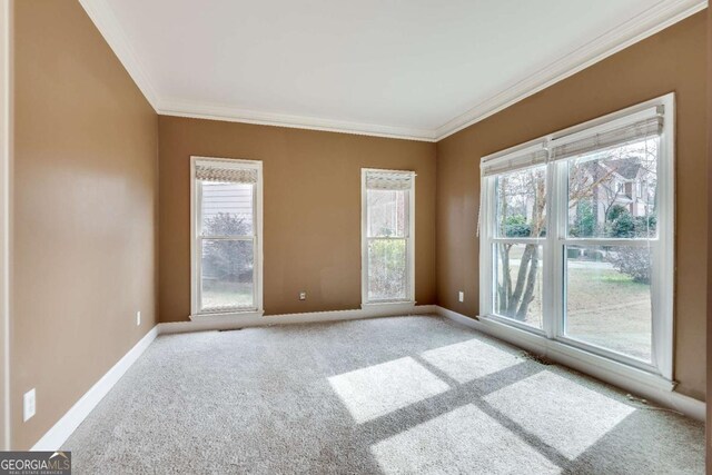 unfurnished room with carpet, baseboards, and crown molding