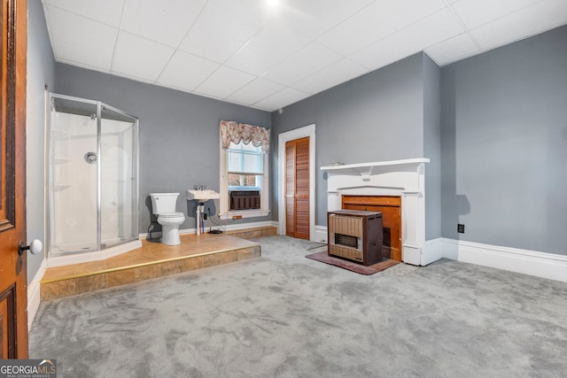 unfurnished living room with a fireplace, carpet flooring, and baseboards