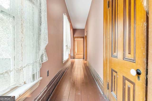 hallway with baseboards and hardwood / wood-style floors