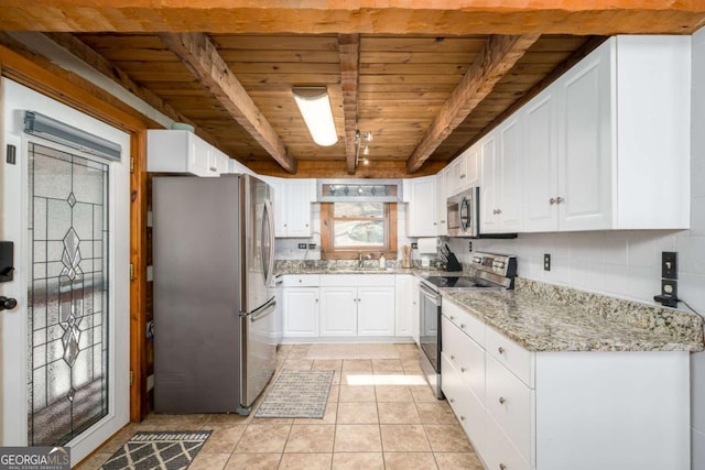kitchen with beamed ceiling, a sink, white cabinetry, appliances with stainless steel finishes, and wood ceiling