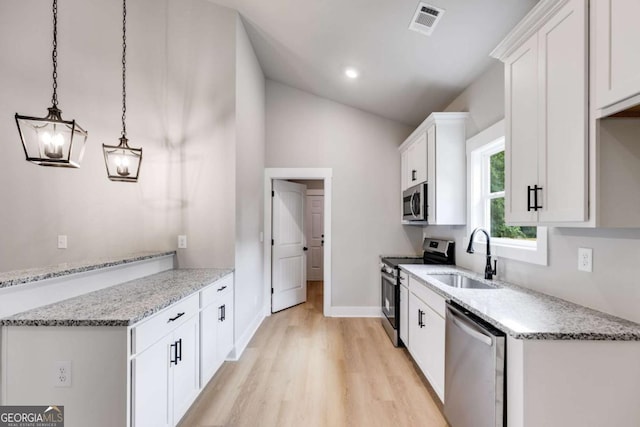 kitchen with white cabinetry, visible vents, stainless steel appliances, and a sink