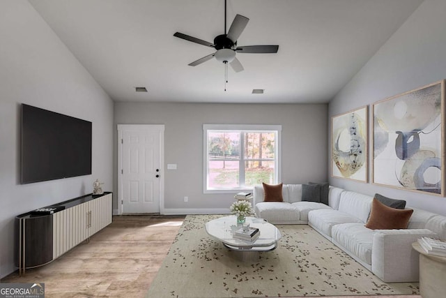 living room featuring light wood-style floors, baseboards, and a ceiling fan