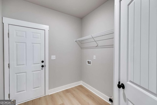 clothes washing area with hookup for a washing machine, light wood-type flooring, laundry area, and baseboards