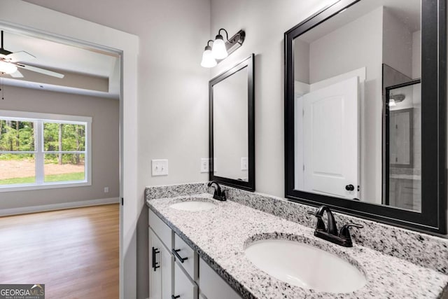 full bath featuring double vanity, wood finished floors, a sink, and a shower with shower door