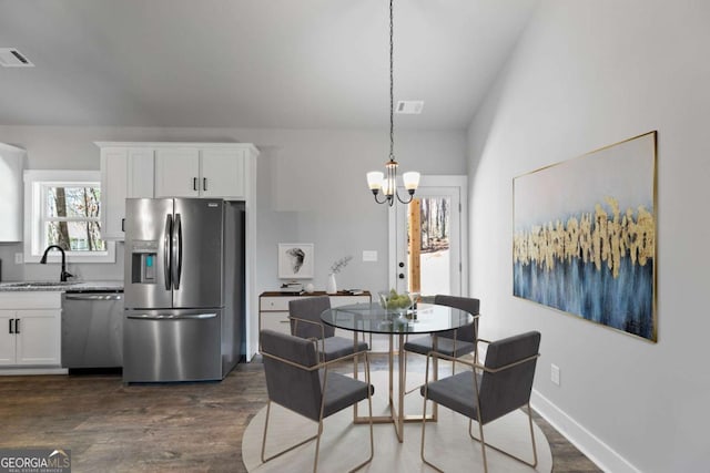 dining space featuring dark wood-style floors, baseboards, visible vents, and an inviting chandelier