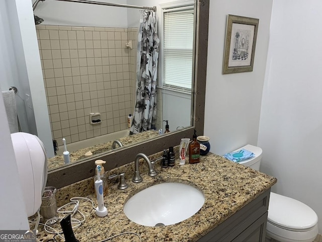 bathroom with shower / bathtub combination with curtain, vanity, and toilet