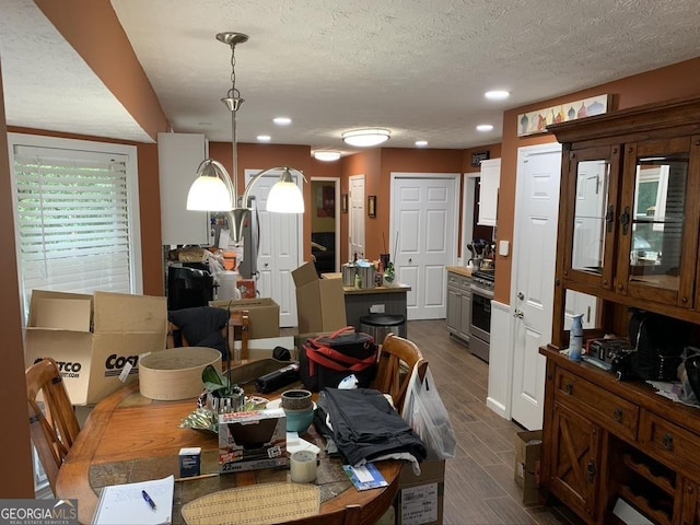 dining area with a textured ceiling, wood finish floors, and recessed lighting