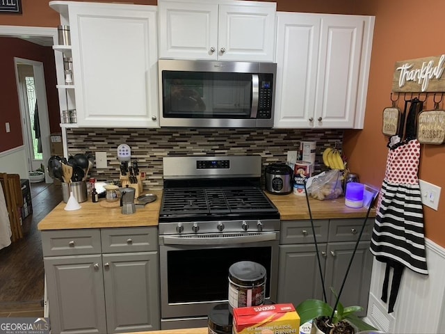 kitchen with appliances with stainless steel finishes, gray cabinets, and backsplash