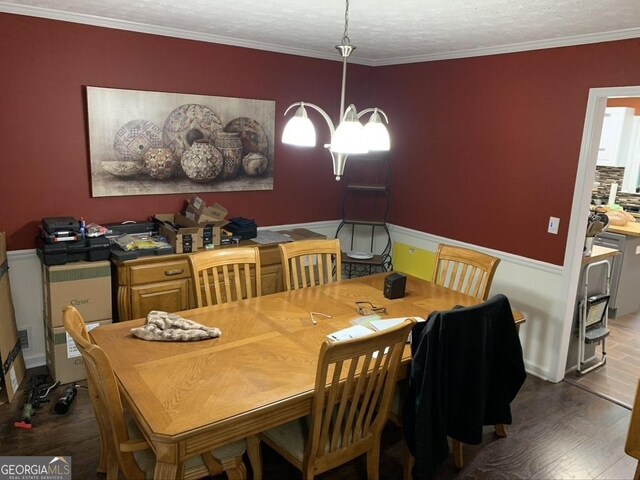 dining space with crown molding, a textured ceiling, and wood finished floors