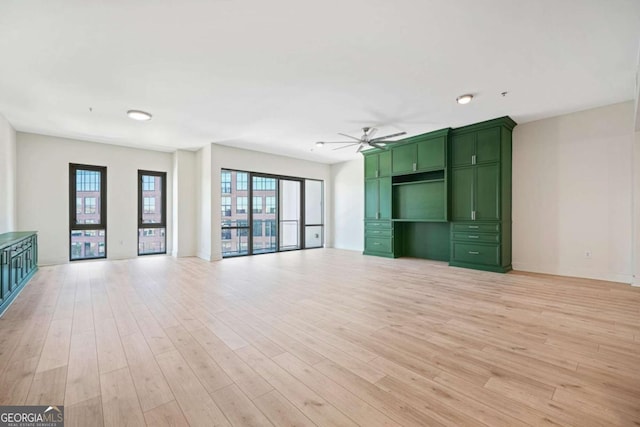 unfurnished living room featuring light wood-style floors, ceiling fan, and baseboards