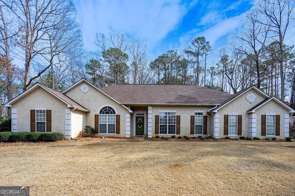 ranch-style home featuring a front yard and stucco siding