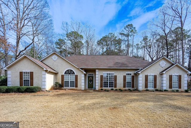 ranch-style home featuring a front yard and stucco siding