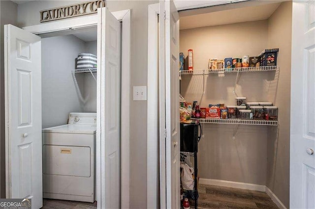 clothes washing area featuring laundry area, washer / clothes dryer, wood finished floors, and baseboards