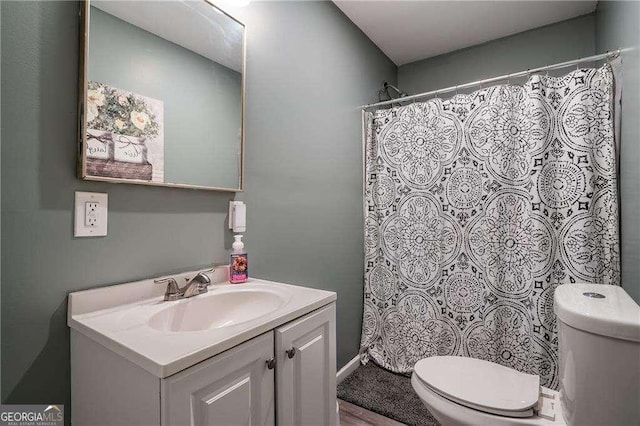 bathroom with toilet, curtained shower, and vanity