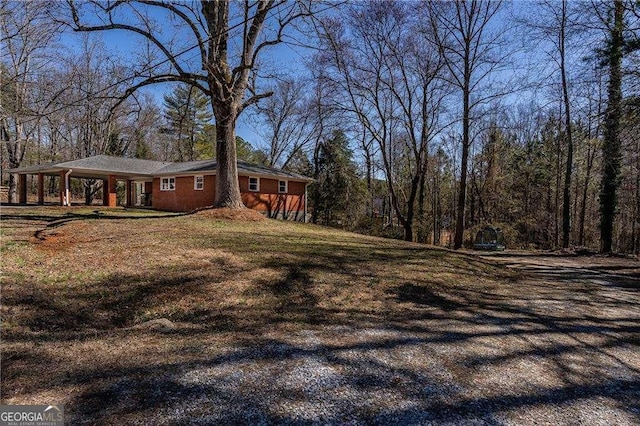 view of side of home featuring a lawn and brick siding