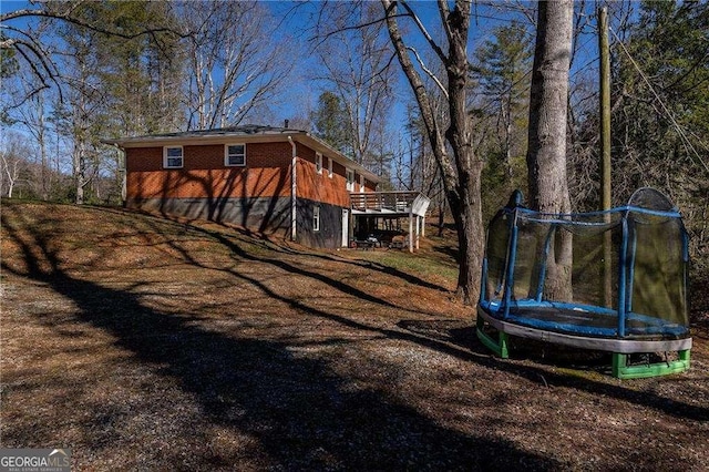 exterior space with a trampoline and a deck