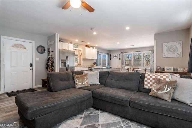 living room with light wood-style flooring and a ceiling fan