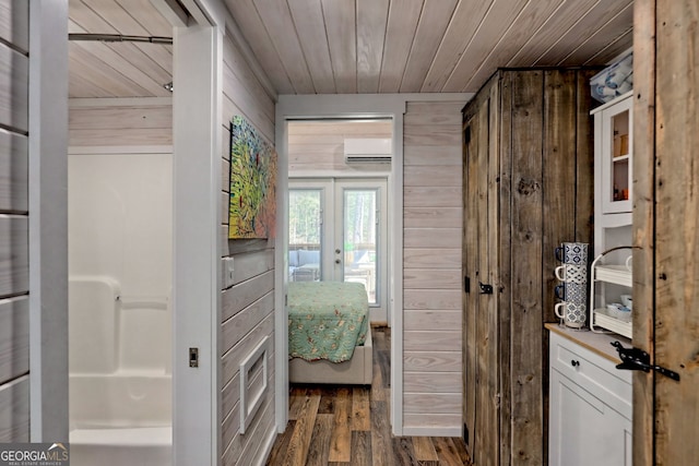 interior space with french doors, wooden walls, wood finished floors, wooden ceiling, and a wall mounted air conditioner