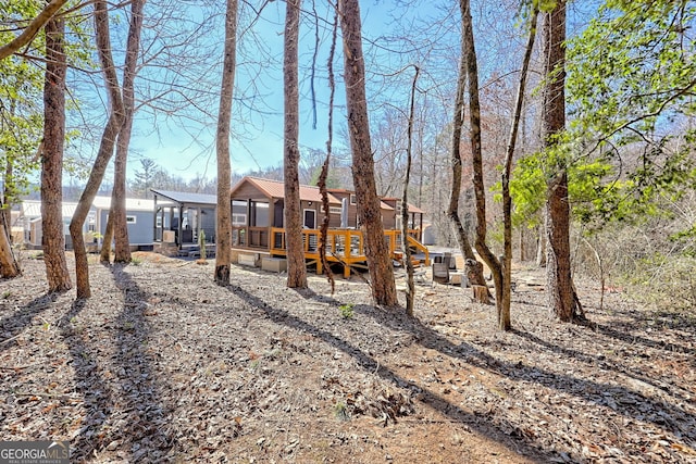 rear view of house featuring metal roof and a wooden deck