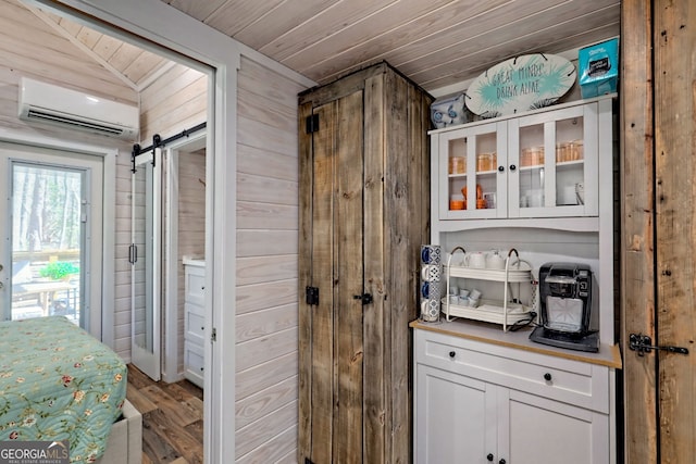 bar featuring a barn door, light wood-style flooring, wood walls, wood ceiling, and an AC wall unit