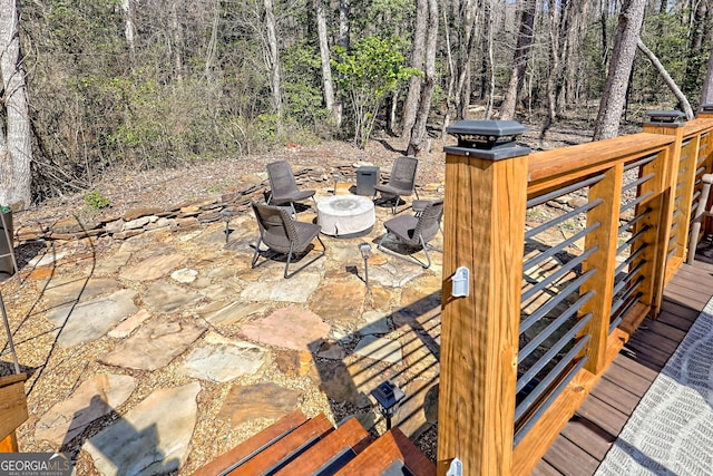 view of patio featuring a fire pit and a forest view