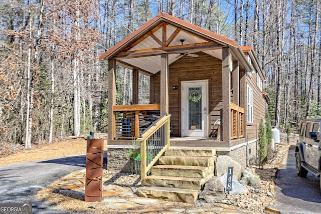 rustic home with covered porch and a wooded view