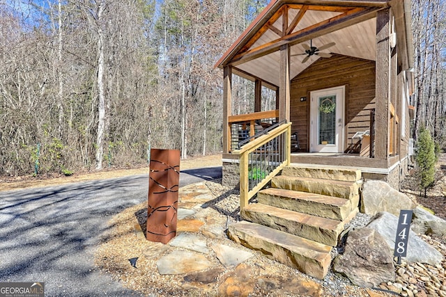 doorway to property with ceiling fan and a porch