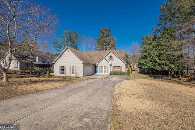 view of front of house with driveway, an attached garage, and a front lawn