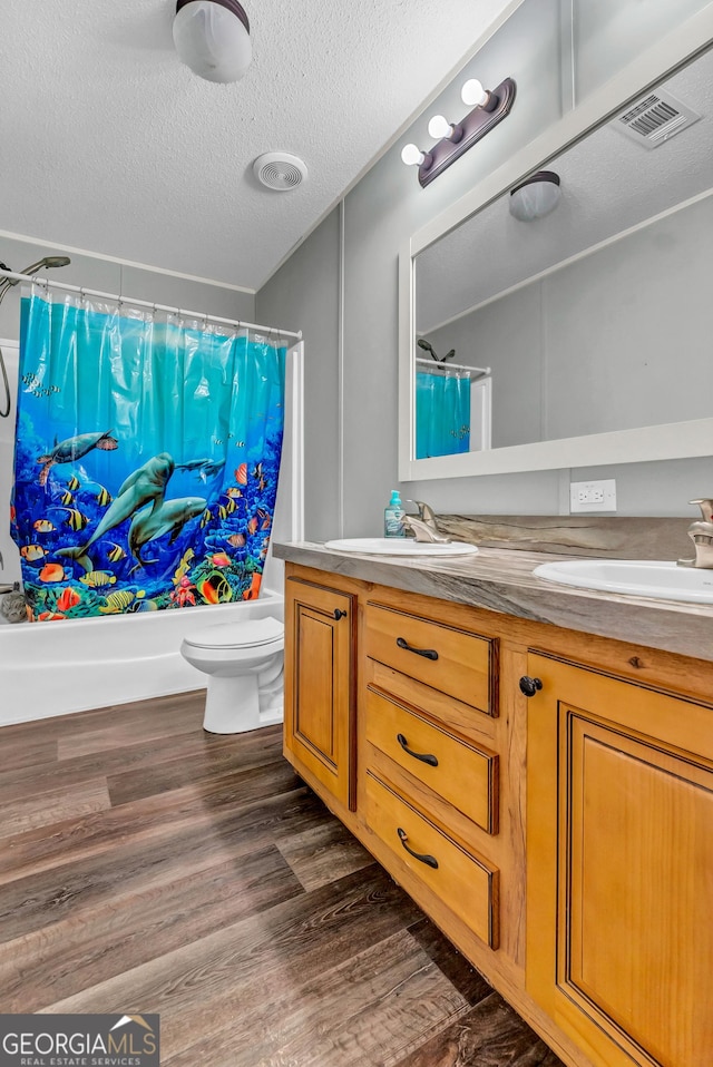 bathroom with double vanity, a sink, and wood finished floors