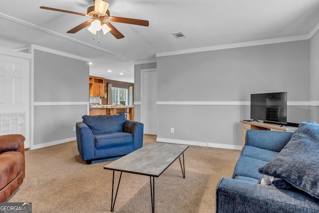 living room with ornamental molding, light colored carpet, visible vents, and baseboards