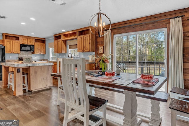 dining area with light wood-type flooring, an inviting chandelier, visible vents, and recessed lighting