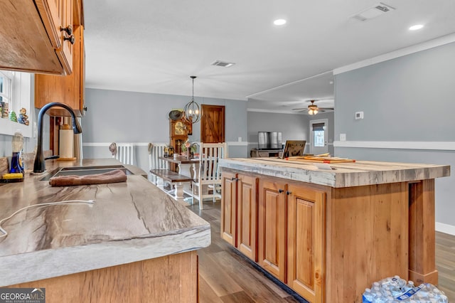 kitchen featuring visible vents, a sink, and wood finished floors