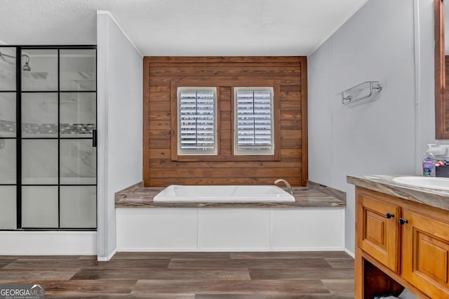 full bath with a garden tub, a shower stall, wood finished floors, and vanity