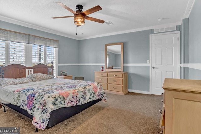 bedroom with a ceiling fan, visible vents, crown molding, and light carpet