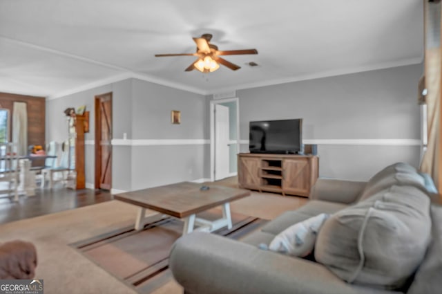 living area with ornamental molding, light wood-type flooring, and ceiling fan