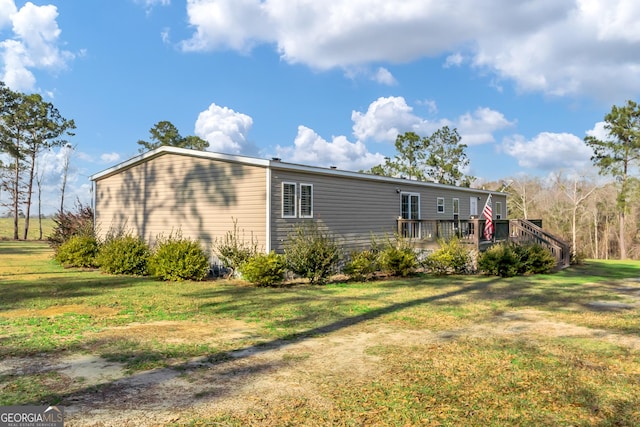 view of home's exterior with a yard and a wooden deck