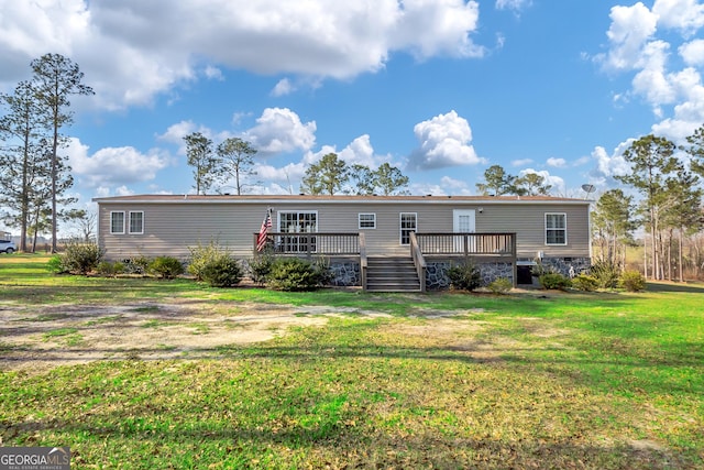 view of front of house with a front yard and a wooden deck