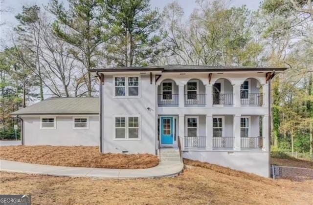 view of front of property featuring a porch, crawl space, a balcony, and stucco siding