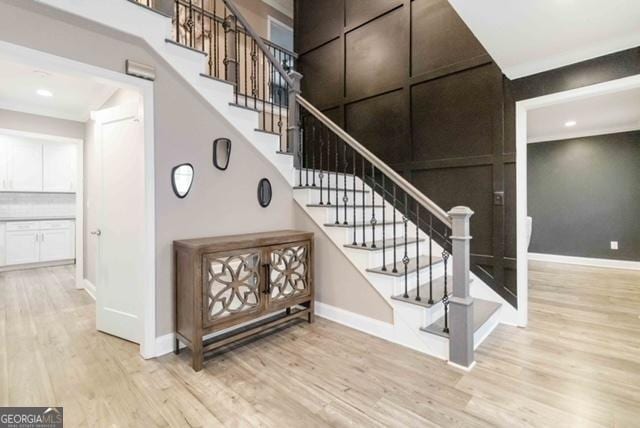 stairs featuring recessed lighting, a towering ceiling, baseboards, and wood finished floors