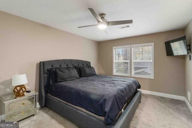 bedroom with a ceiling fan, light colored carpet, visible vents, and baseboards