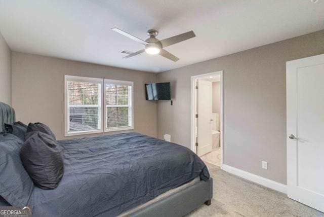 bedroom with visible vents, a ceiling fan, light carpet, ensuite bath, and baseboards