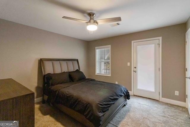 bedroom with a ceiling fan, light colored carpet, baseboards, and multiple windows