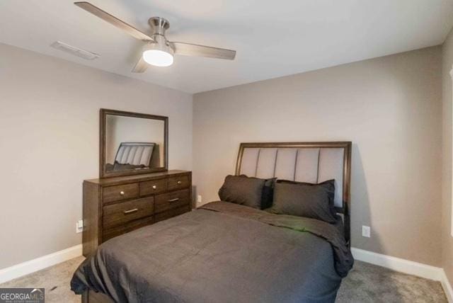 carpeted bedroom with a ceiling fan, visible vents, and baseboards