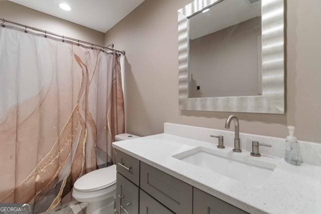 bathroom featuring curtained shower, vanity, and toilet