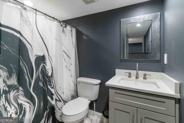 full bathroom with curtained shower, toilet, visible vents, vanity, and baseboards